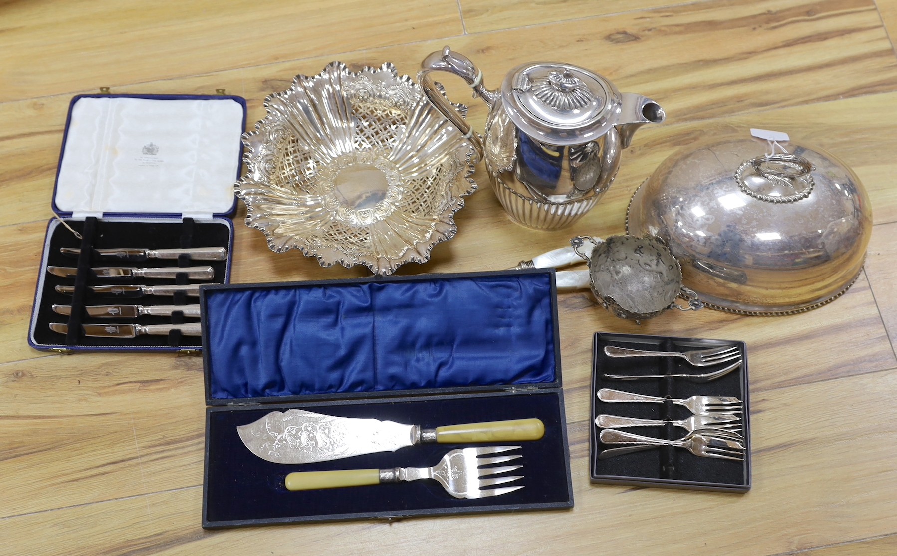 A cast white metal bowl and a collectio of plated items including a hot water pot, meat cover, cased flatware, etc.